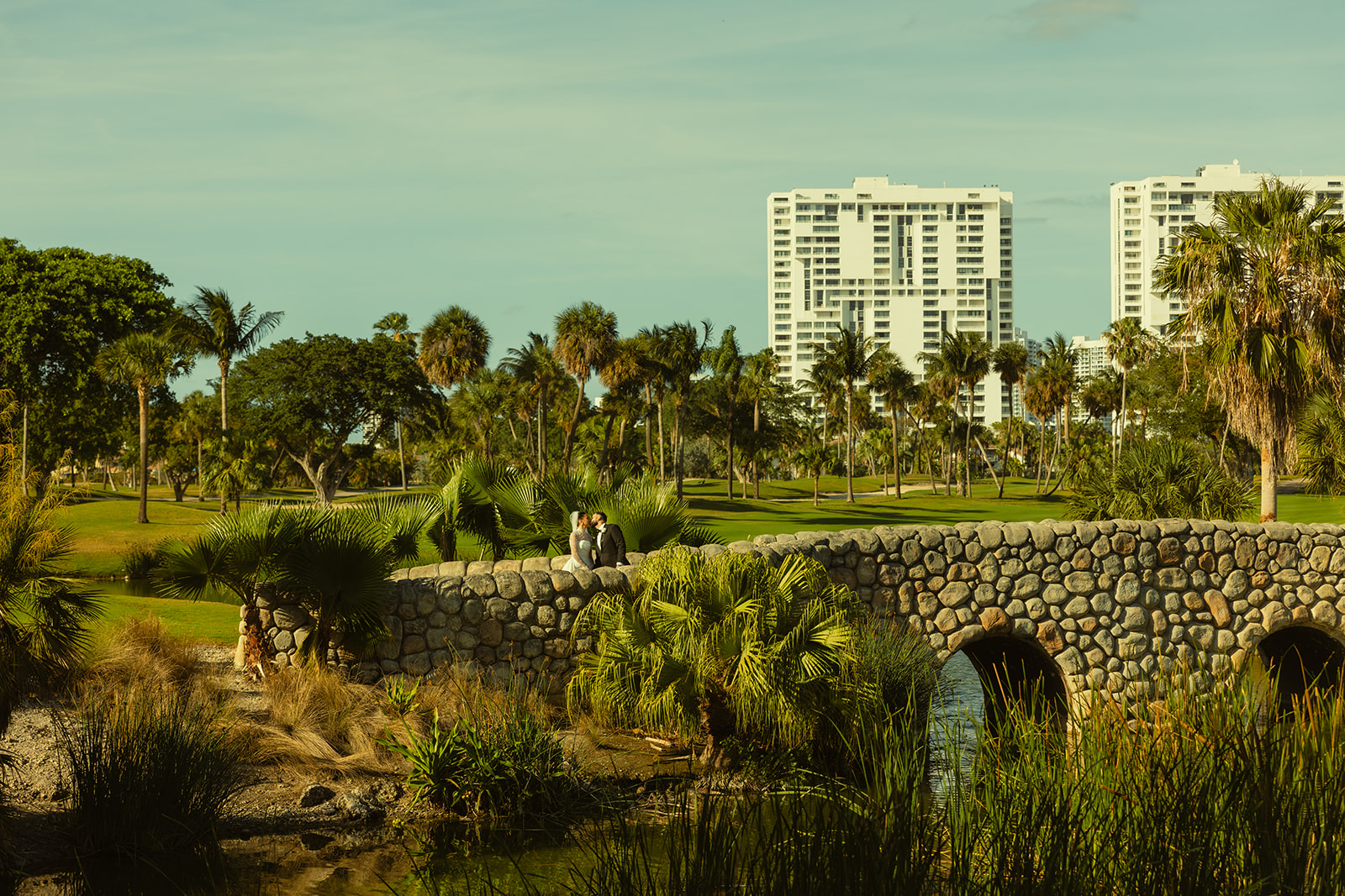 Bride and Groom Kissing on Golf Course Bride in JW Marriott Turnberry in Miami Florida. Documentary Wedding Photographer