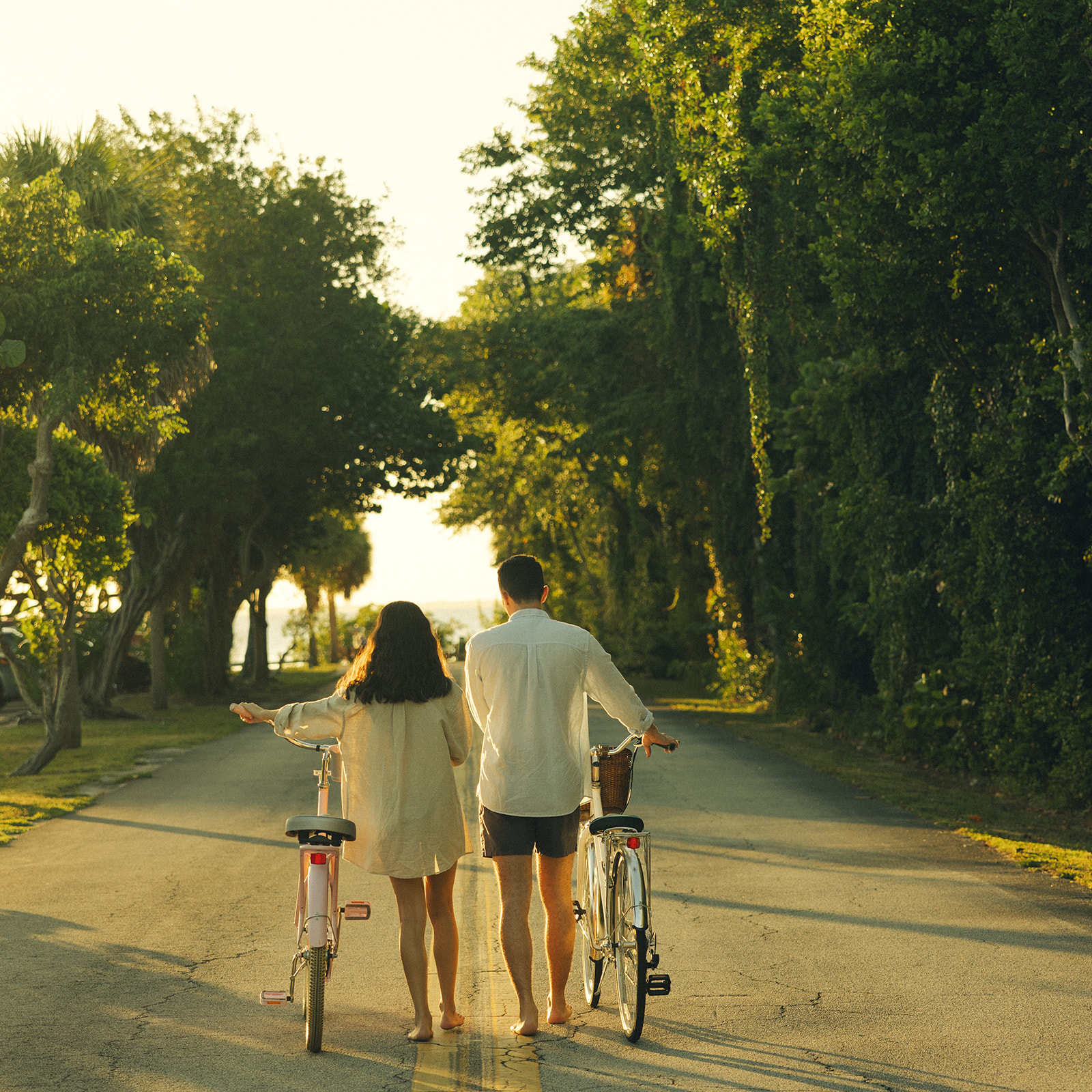 Documentary Walking with Bike into Sunset Couples Engagement Session In Miami Beach