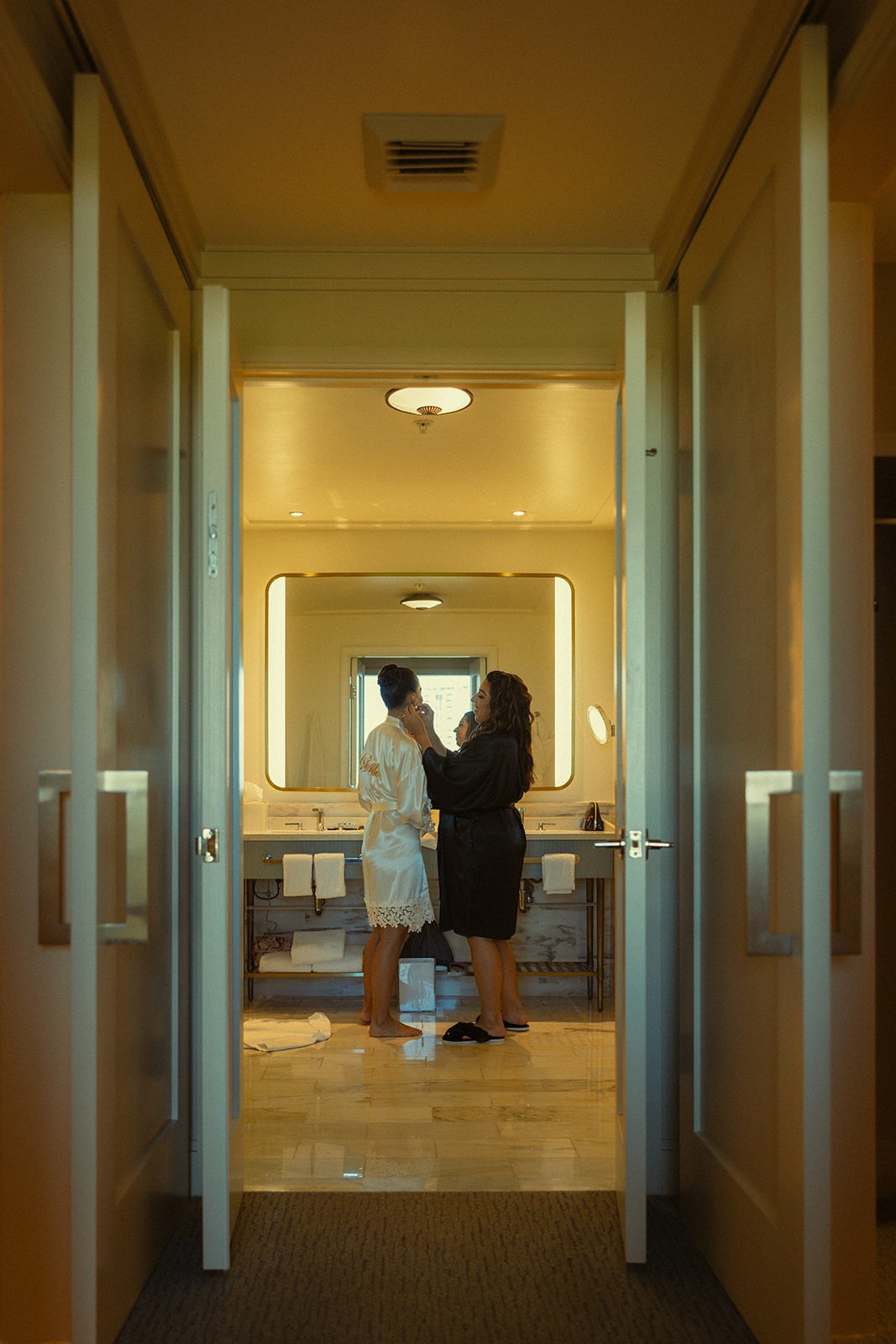 Candid Bride Getting Ready with Sister for Wedding at JW Miami Turnberry Resort & Spa in Aventura, Florida