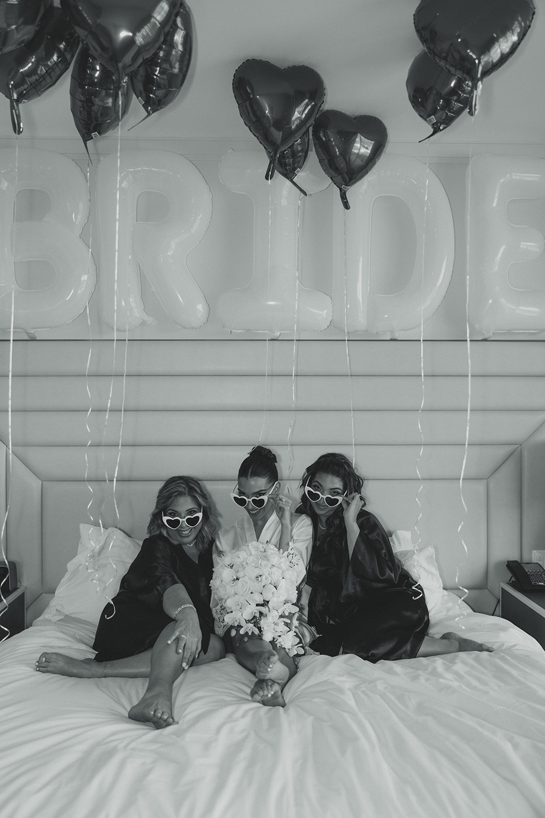 Bride, Mother, and Sister Getting Ready Portrait with Trendy White Heart Glasses for Wedding at JW Miami Turnberry Resort & Spa in Aventura, Florida in Black and white