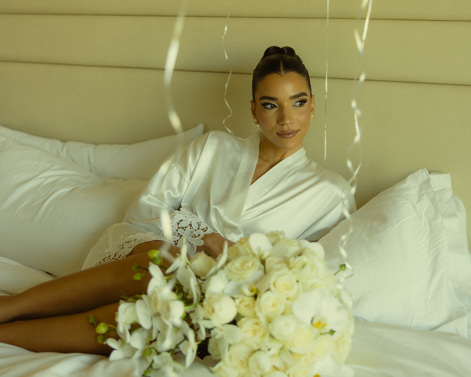 Bride Editorial Solo Portraits in Bride Robe Getting Ready Portraits with her White Roses and White Orchid Wedding Bouquet for her Wedding at JW Miami Turnberry Resort & Spa in Aventura, Florida