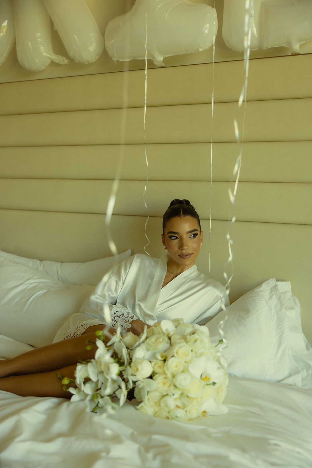 Bride Editorial Solo Portraits in Bride Robe Getting Ready Portraits with her White Roses and White Orchid Wedding Bouquet for her Wedding at JW Miami Turnberry Resort & Spa in Aventura, Florida