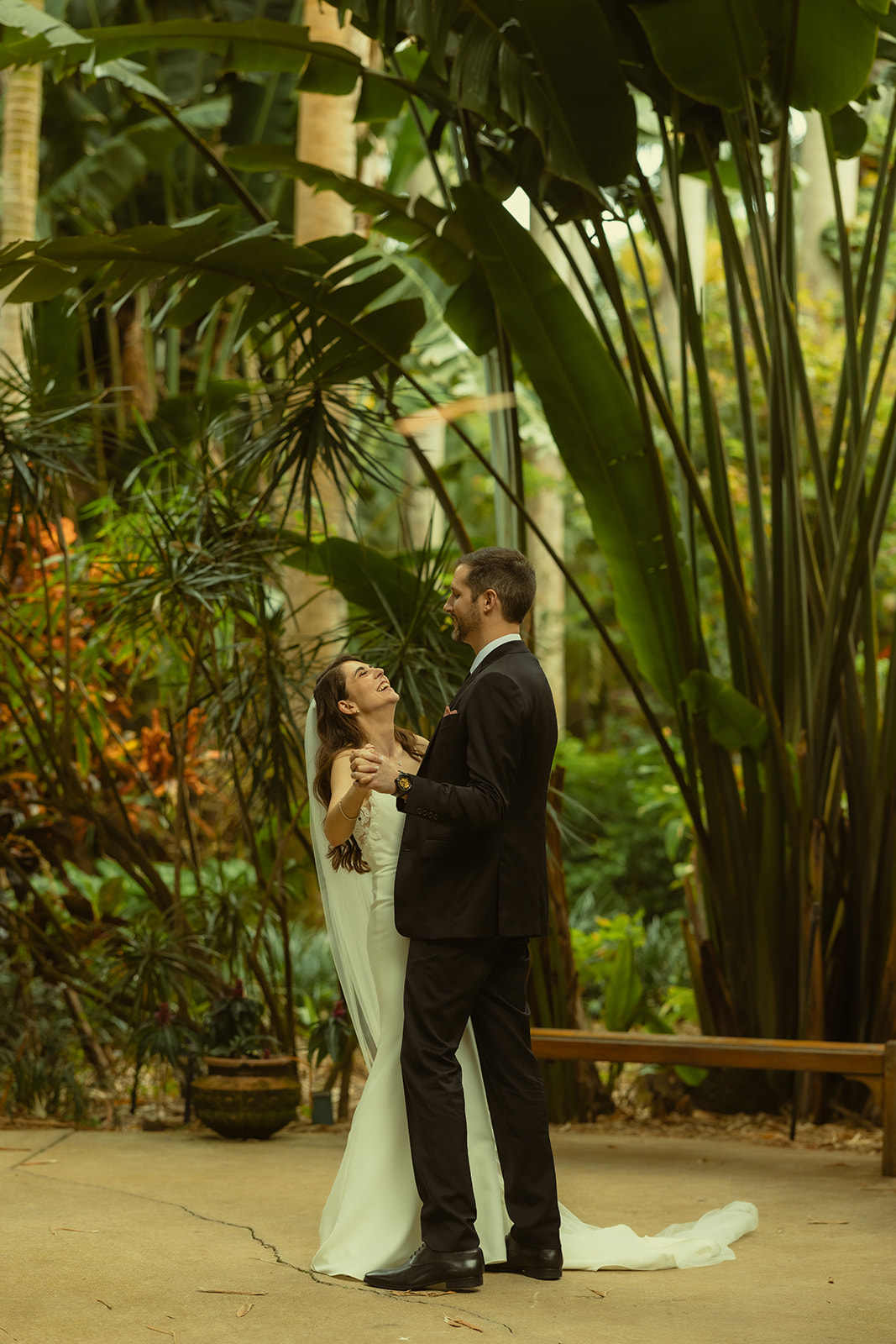 Laughing Bride and Groom practicing First Dance between a garden in St.Petersburg