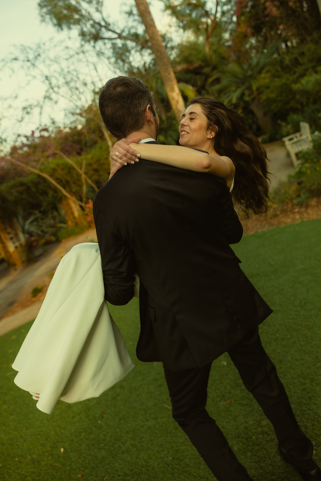 Laughing Bride Being Carried by Groom Playful Newly Wed Portraits in St.Petersburg Garden Wedding