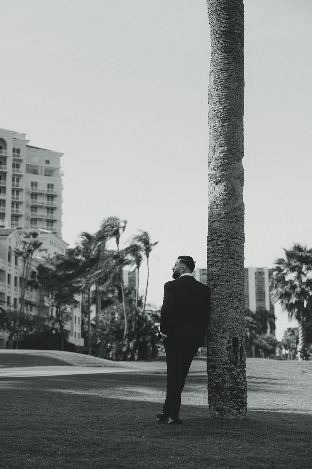 Editorial Groom Portraits Looking Away in JW Marriott Turnberry in Aventura Against Tree Trunk Bark in Black and White