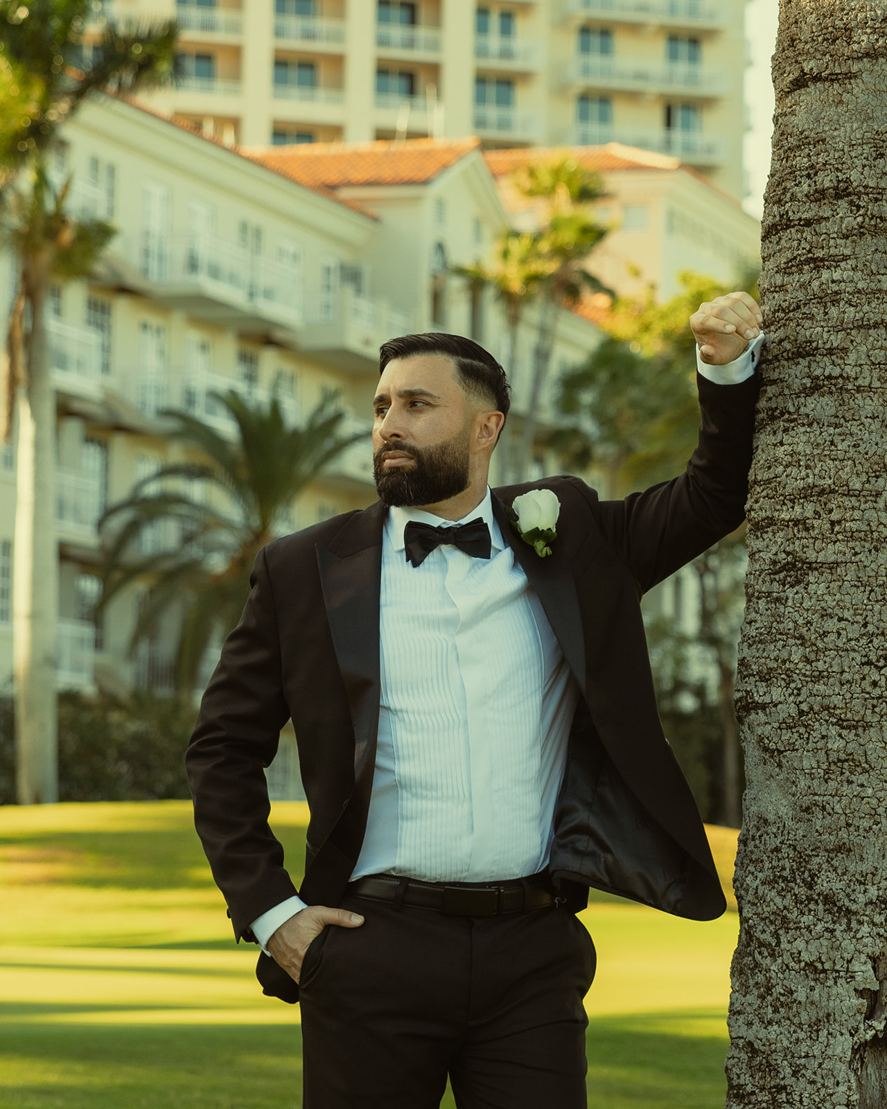 Editorial Up Close Groom Portraits in JW Marriott Turnberry in Aventura Against Tree Trunk Bark Black Suit and Black Bow Tie.