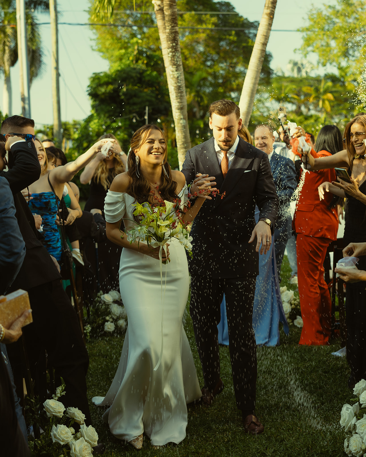 Newly Weds walking down the aisle rice throwing wedding ceremony dreamy and elevated intimate backyard wedding by Aileen Ayala Photography