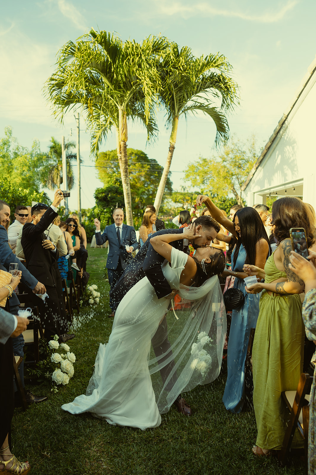 Newly Weds walking down the aisle rice throwing bride dip wedding ceremony dreamy and elevated intimate backyard wedding by Aileen Ayala Photography