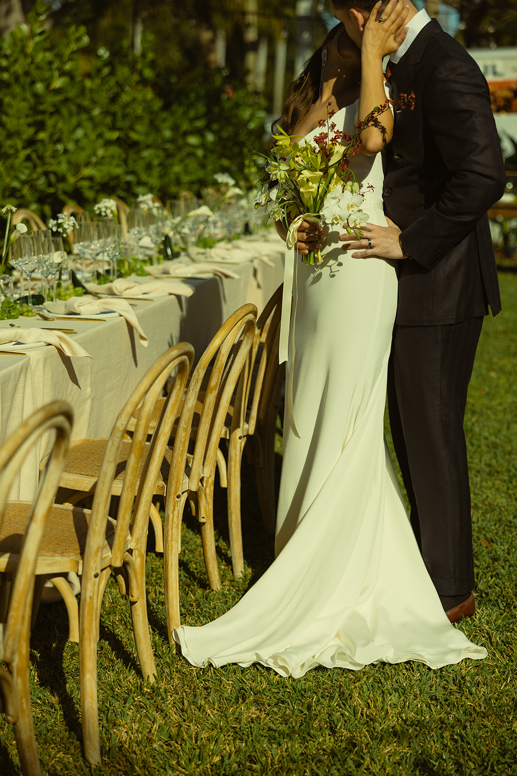 Kissing Bride & Groom couple portraits near wedding tablescape dreamy and elevated intimate backyard wedding by Aileen Ayala Photography