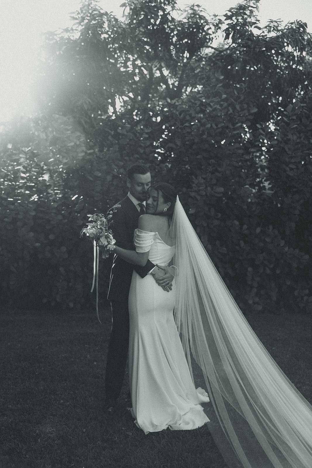 Hugging Black and White Sun Flare Bride & Groom couple portraits dreamy and elevated intimate backyard wedding by Aileen Ayala Photography