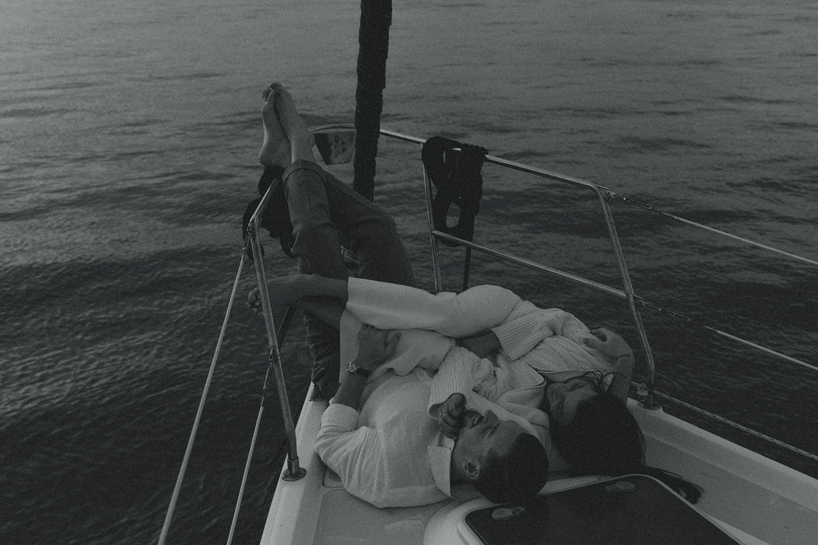 Sailboat Engagement Session in Miami, Laying on Sailboat Cuddled Black and White