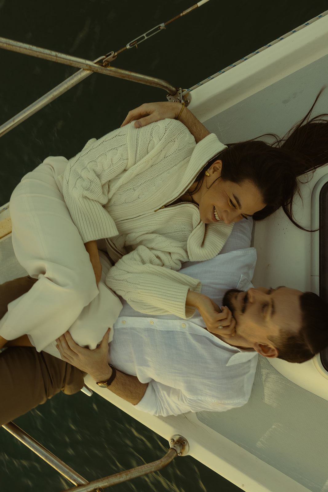 Sailboat Engagement Session in Miami, Laying on Sailboat Cuddled Laughing