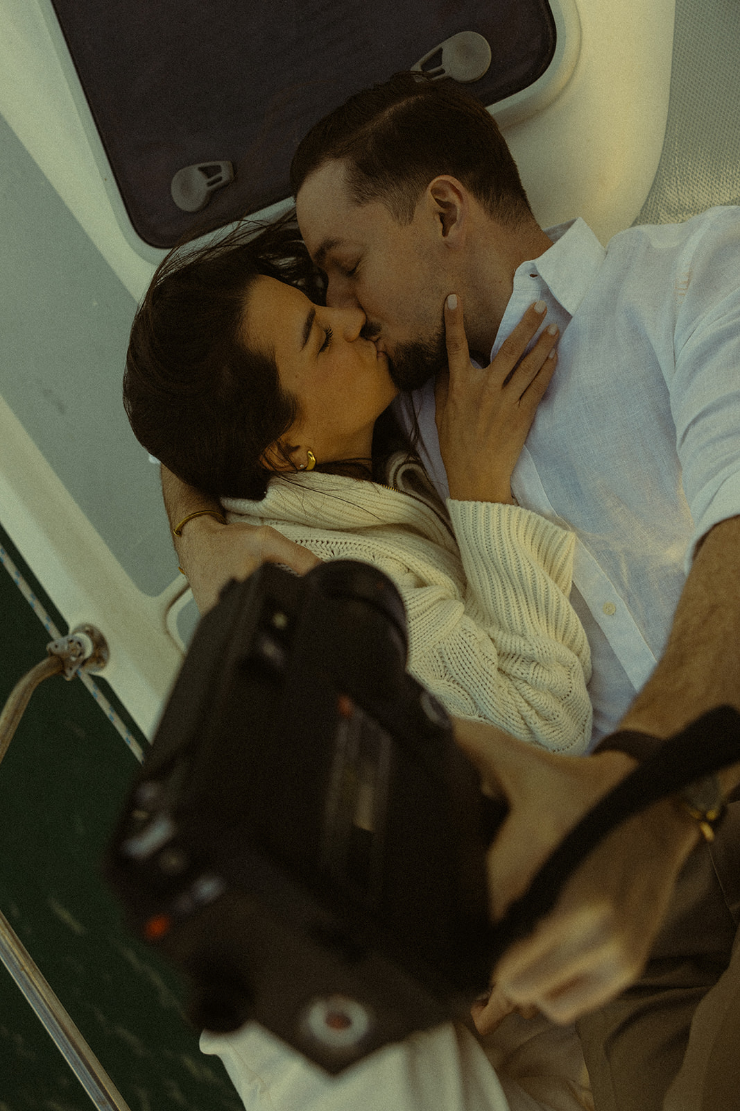 Sailboat Engagement Session in Miami, Laying on Sailboat Cuddled Super 8 Couple Kissing