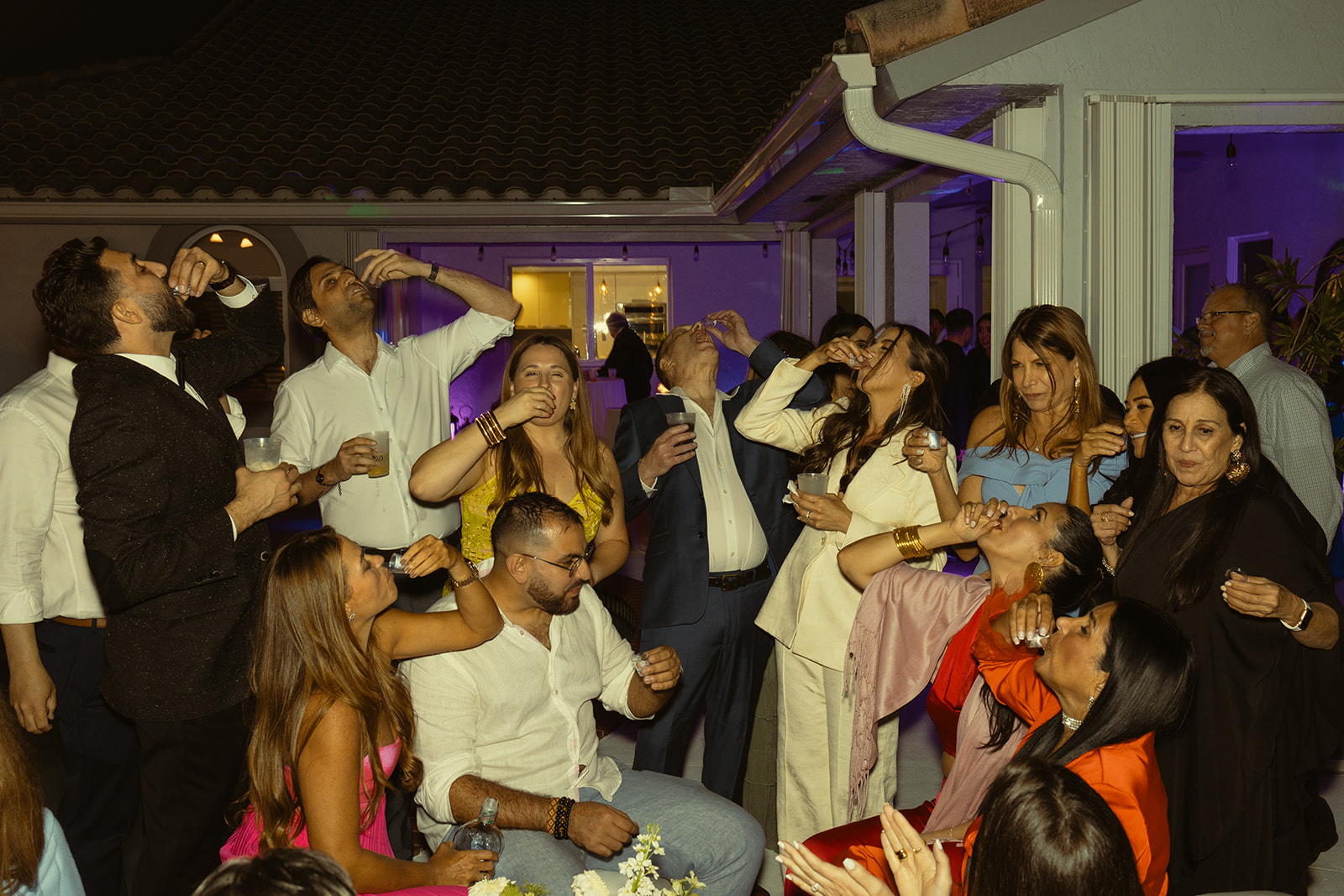 bride and guests taking a shot of aguardiente reception dreamy and elevated intimate backyard wedding by Aileen Ayala Photography 