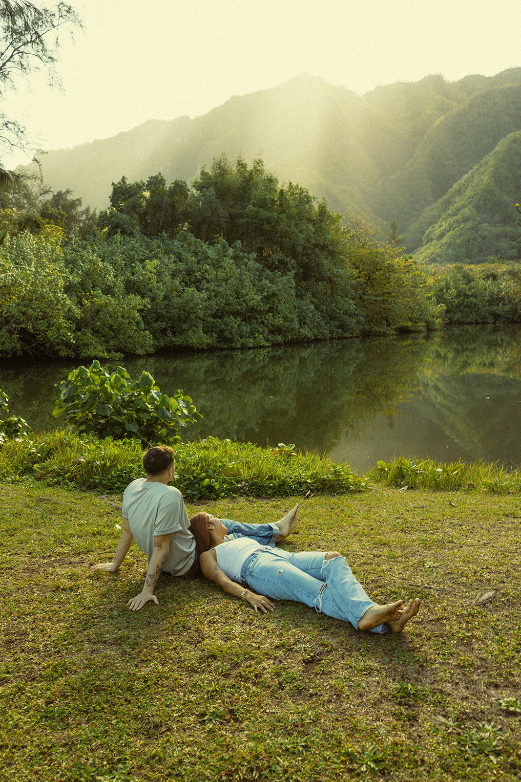 Lush Lakeside Mountains Oahu Hawaii Engagement Pictures Laying Couple North Shore