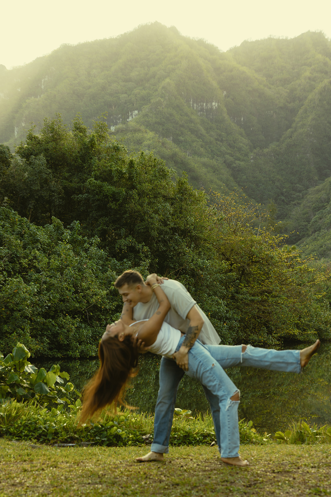 Lush Lakeside Mountains Oahu Hawaii Engagement Pictures Twirling and Dancing Couple North Shore