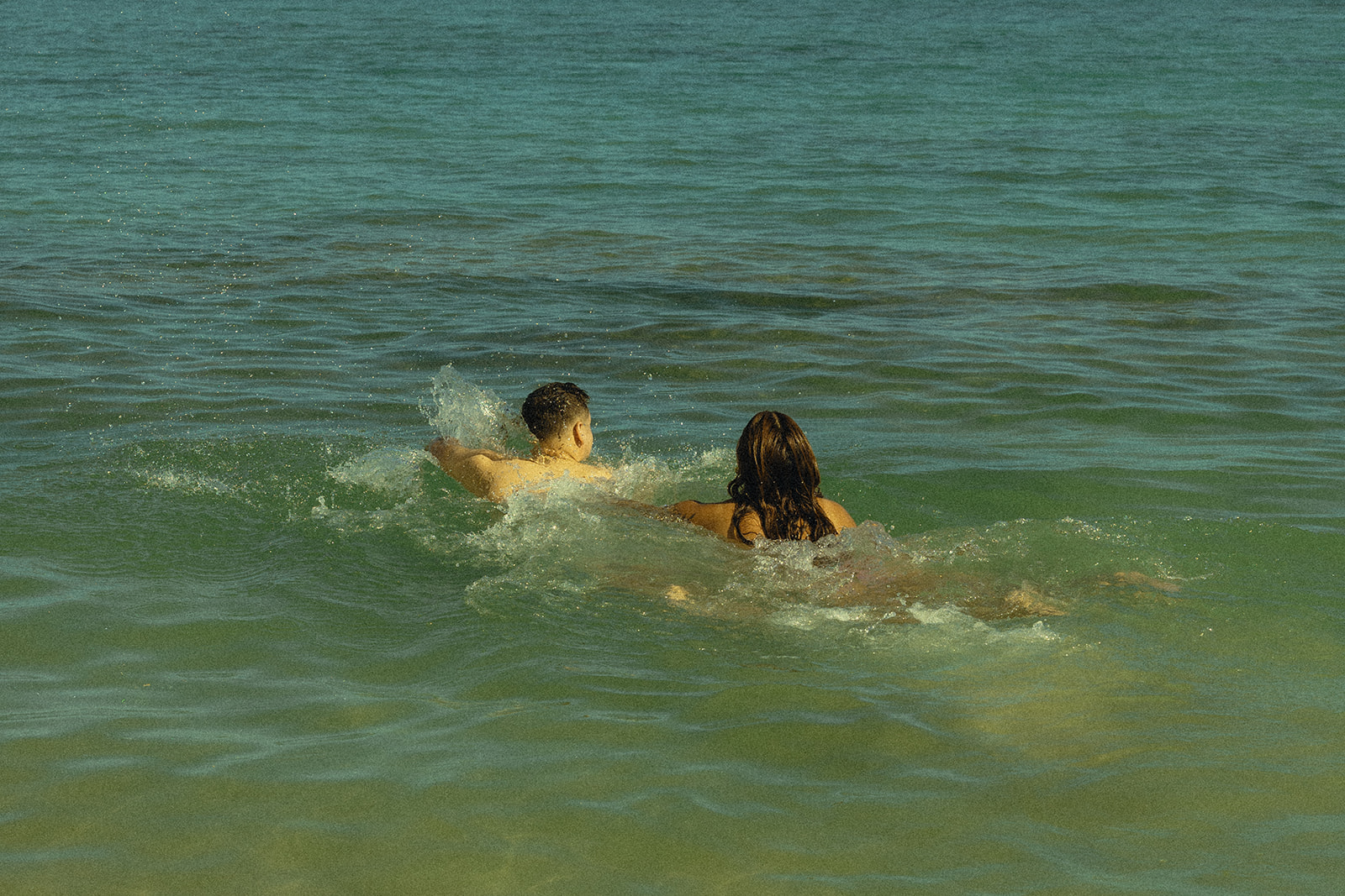 Backdrop Playing in Water in Beach North Shore Oahu Hawaii Adventure Couple Pictures