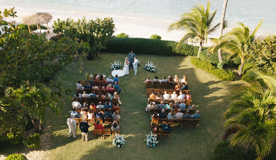 High-angle view of an intimate beachside wedding ceremony organized on a manicured lawn, demonstrating how hiring a wedding planner helps seamlessly coordinate outdoor venues and guest seating.